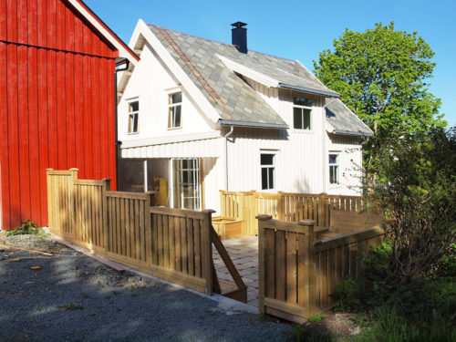 Austrått agrotourismus, Kårstua, ein weißes Haus in der Mitte mit ein Terrasse vor, eine rote Scheune auf der linken Seite