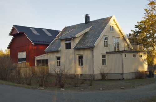 Austrått, Austrått Agrotourismus, ein weißes Haus und eine rote Scheune ausf der linken Seite
