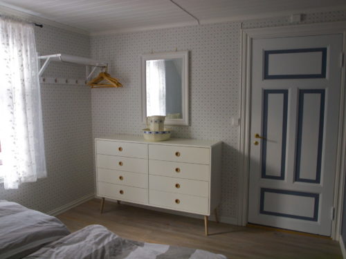 Ferienhaus, Austrått Agrotourismus, Kårstua, Schlafzimmer mit den Farben Blau und Weiß, Weiße Kommode und ein Spiegel oben