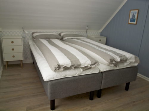 Ferienhaus, Austrått Agrotourismus, Kårstua, Schlafzimmer mit Grauem Doppeltbett, bettwäsche grau und Weiß gestreift, blaue wand